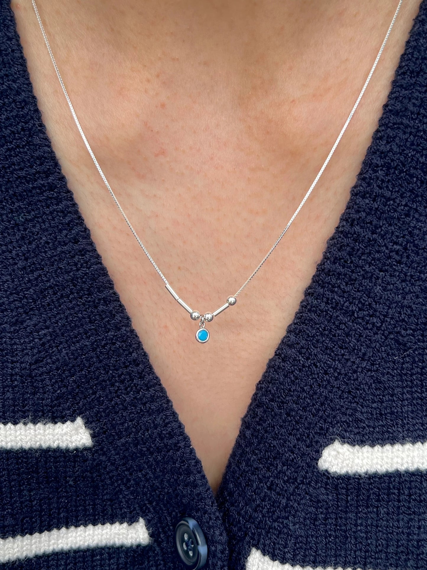 Woman wearing custom morse birthstone necklace as gift talisman