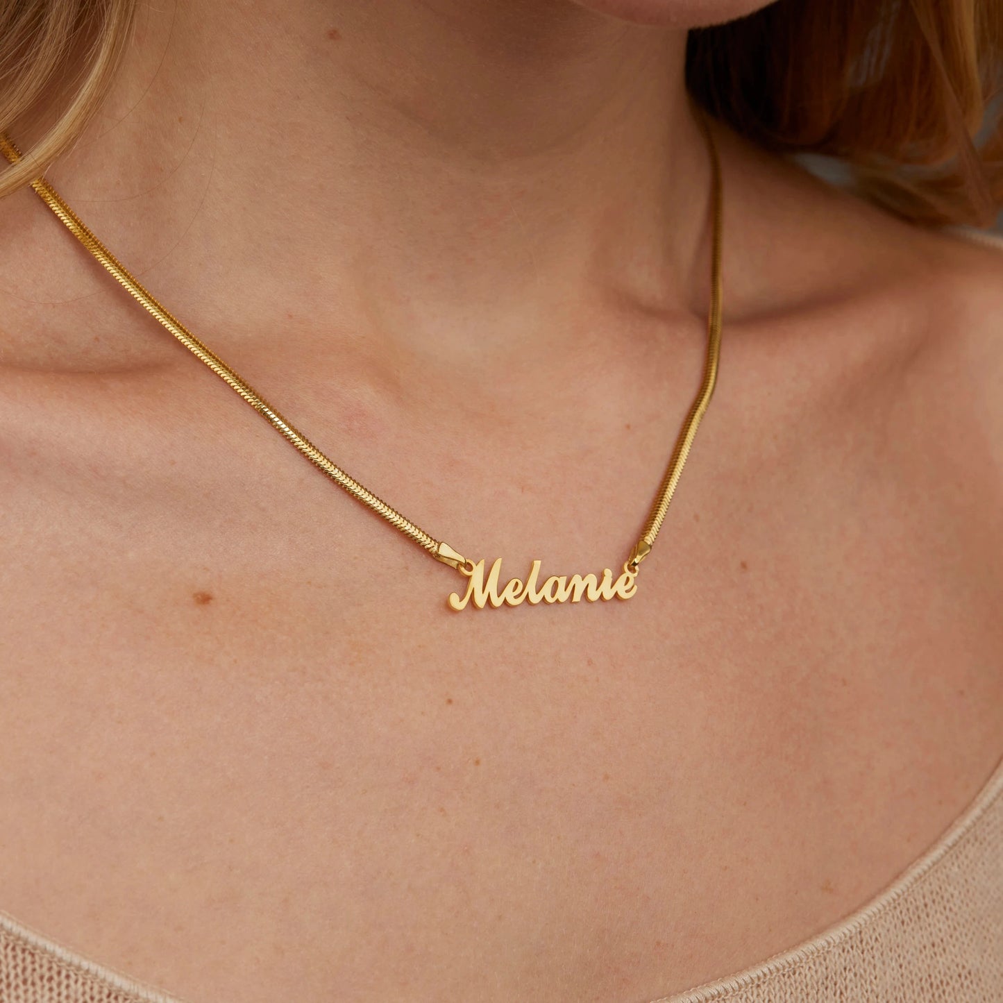 Woman wearing personalized gold name necklace as gift talisman